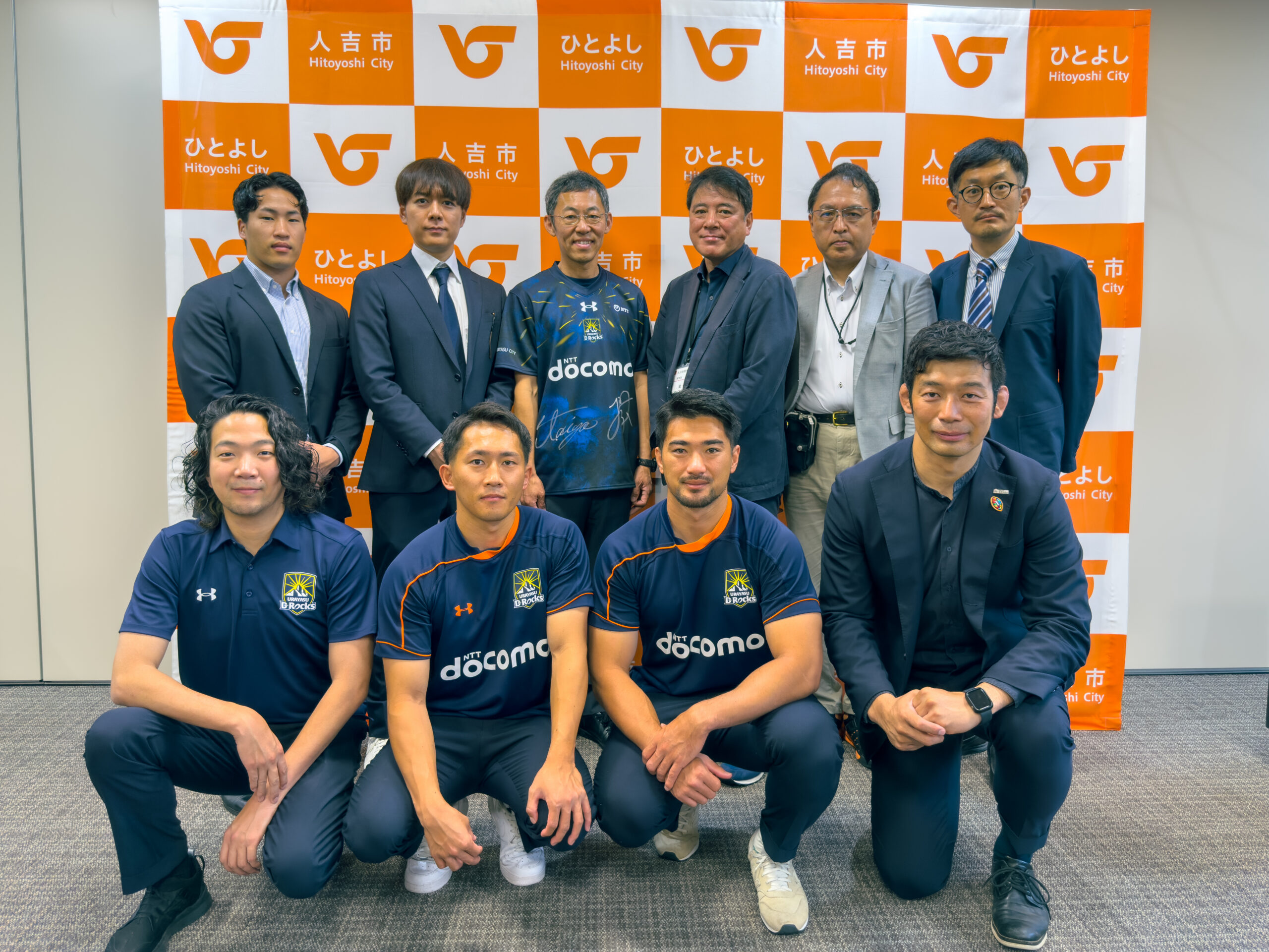 人吉市との連携訪問で撮影された、関係者とスポーツチームメンバーの集合写真